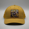 Figs trucker hat in biscuit gold, front view, patch of ripe purple figs on the branch