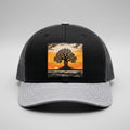Graphe trucker hat in black and grey, front view, patch of a lone tree at sunset with exposed roots