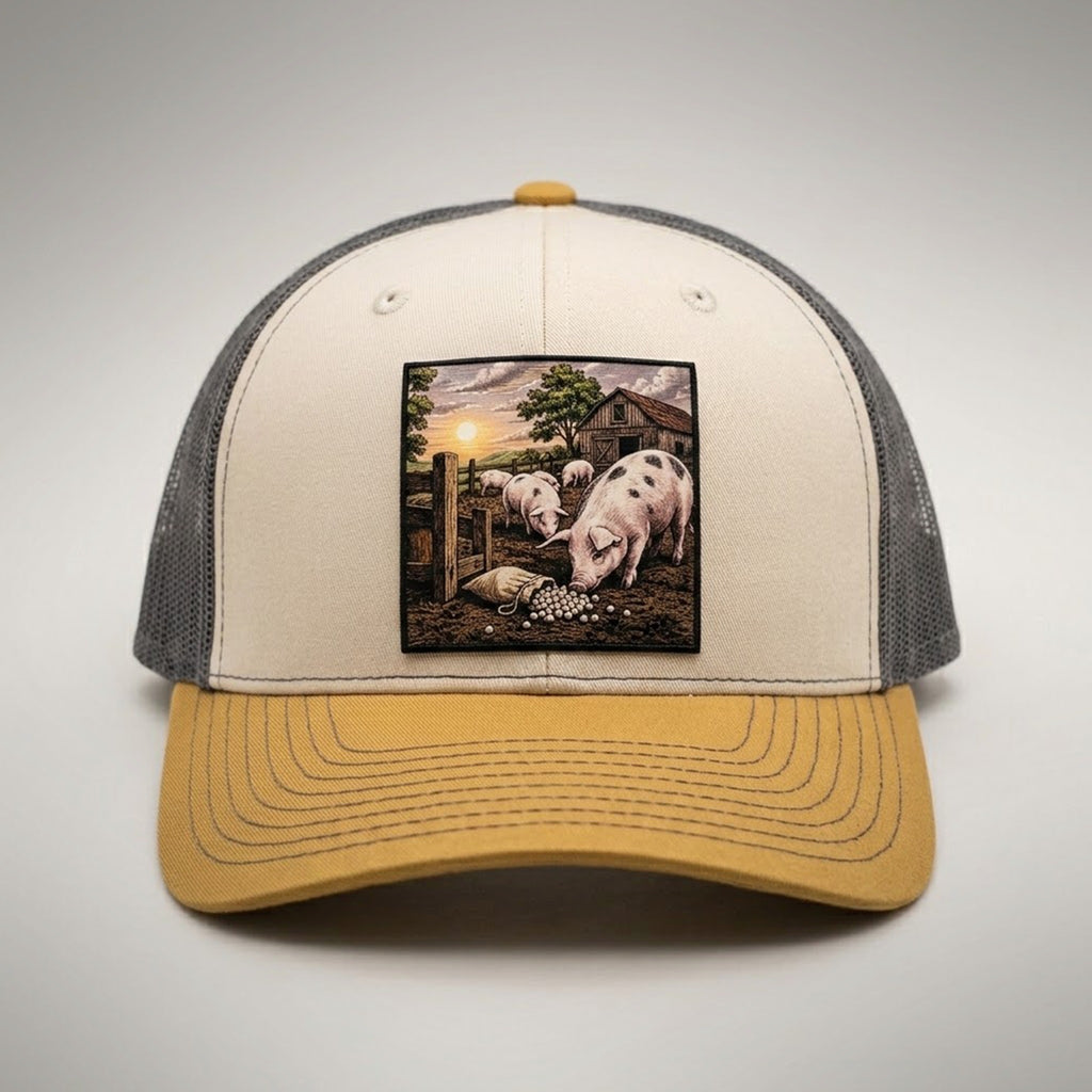 Pearls and Swine trucker hat in birch and gold, front view, patch of pigs in a pen with pearls in the mud