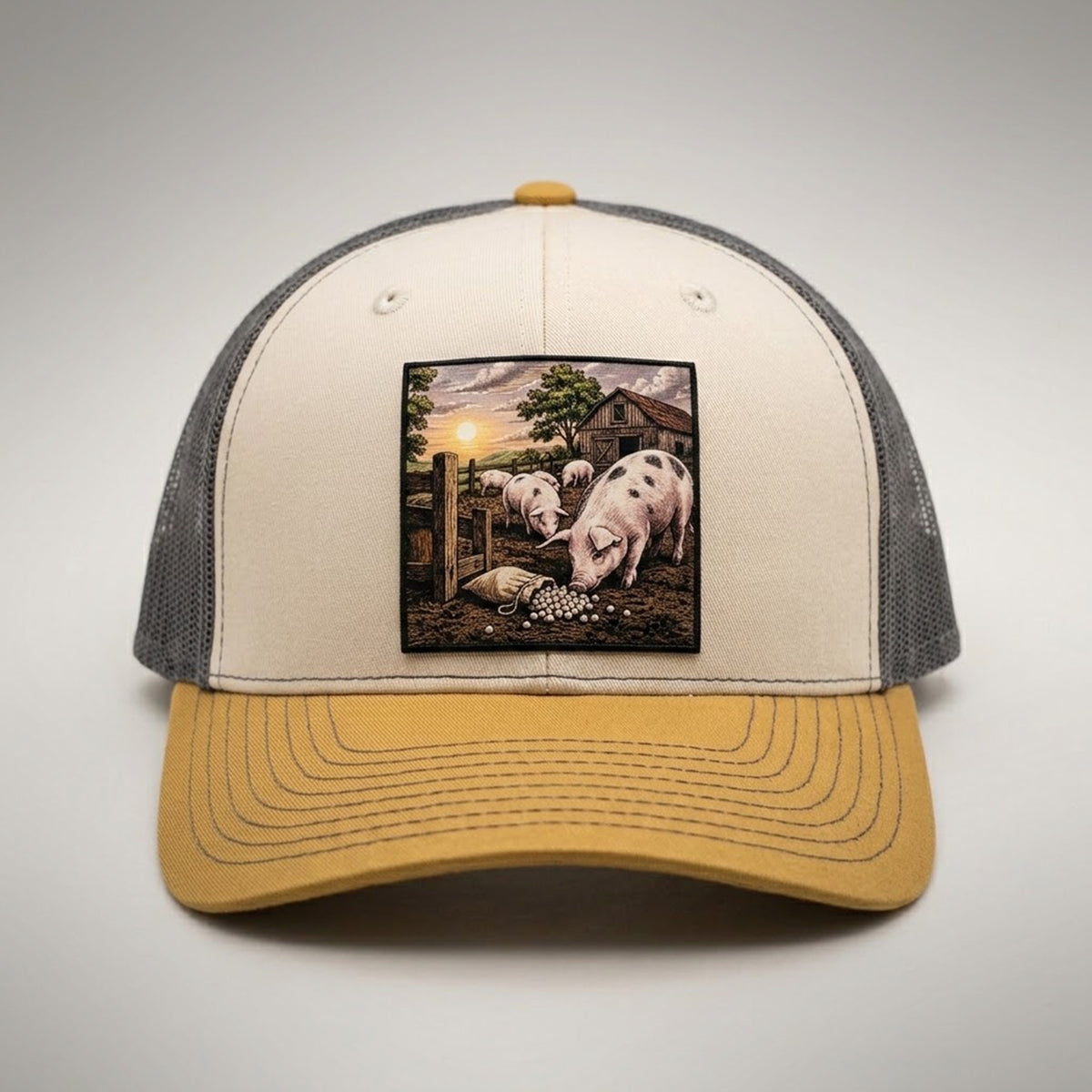 Pearls and Swine trucker hat in birch and gold, front view, patch of pigs in a pen with pearls in the mud